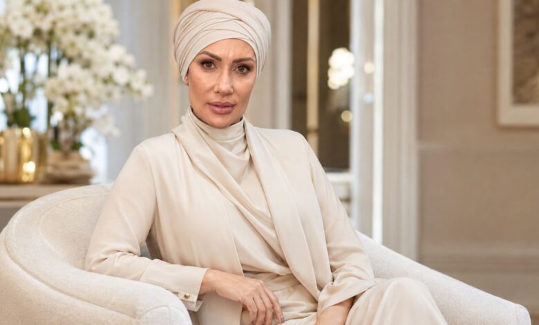 Emily Abraham, co-founder of Love Luxury, seated in an elegant interior wearing a cream outfit and headwrap