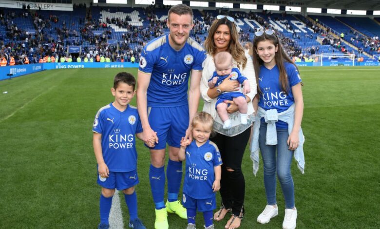 Jamie Vardy posing with his family on a football stadium pitch