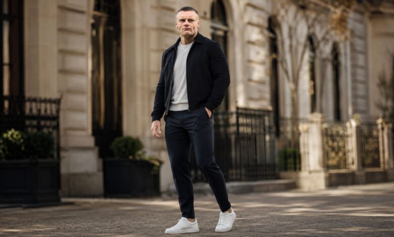 Editorial-style portrait of a footballer in smart casual clothing walking on an upscale city street