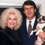 Country music couple posing together with a Boston Terrier at home