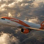 EasyJet Airbus aircraft flying through dramatic clouds on the Lyon to Porto route