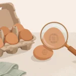 A carton of brown eggs with a magnifying glass checking the code stamped on an eggshell